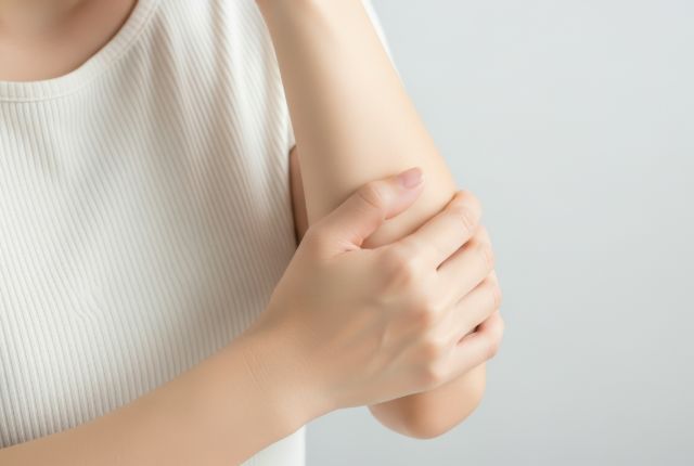 肘に痛みを感じている女性