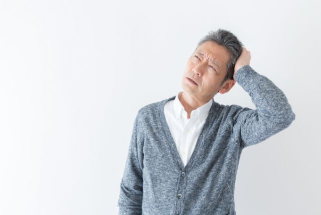 何かを思い出そうとしている高齢男性