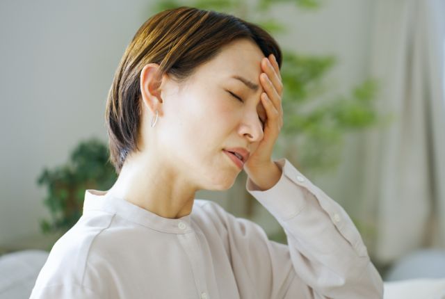 頭に痛みを感じている女性
