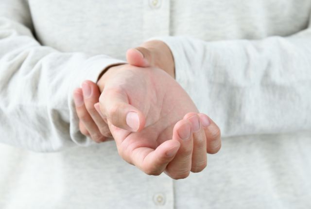 手にしびれを感じている男性